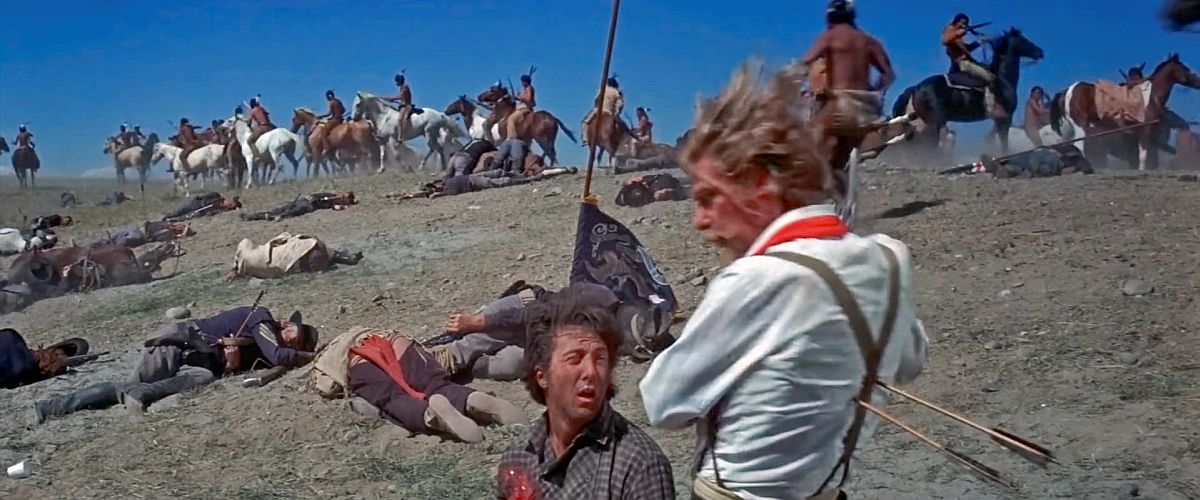 Jack Crabb (Hoffman) looks on as |Custer (Mulligan) gets shot with two arrows in his back. In the background the battle of Little Bighorn is underway with the Indians still active and the US calvary pretty much expired on the ground. 