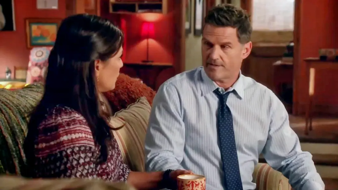 Picture shows Regina at left and John at right sitting down on a sofa and having a chat.